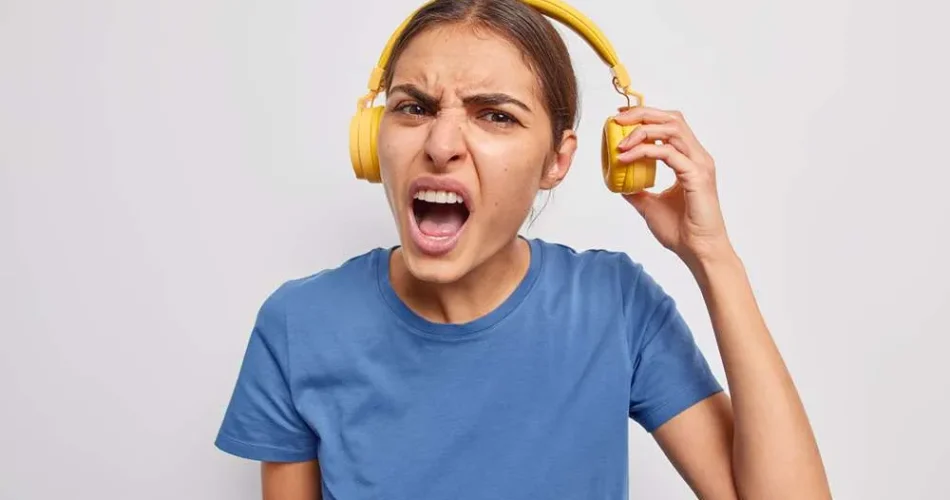 شخصی که در حال گوش دادن به گوشی با هدفون، دچار وزوز گوش شده است.